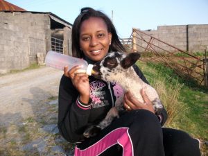 Judy bottle-feeding a lamb.