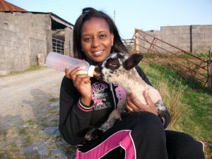 Judy bottle-feeding a lamb.